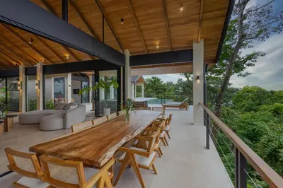 an open deck with a wooden table and chairs at Bahia Rooms in Mal País