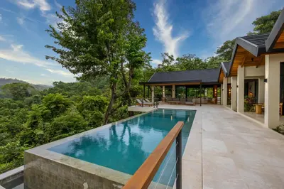 an infinity pool in the backyard of a house at Bahia Rooms in Mal País