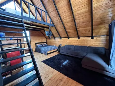 a living room with a couch and a ladder at Cabaña La Trinidad de Dota in El Copey
