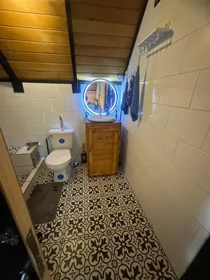 a small bathroom with a toilet and a mirror at Cabaña La Trinidad de Dota in El Copey