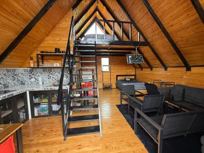 a loft with a spiral staircase in a room at Cabaña La Trinidad de Dota in El Copey