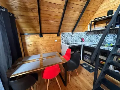a dining room with a table and red chairs at Cabaña La Trinidad de Dota in El Copey