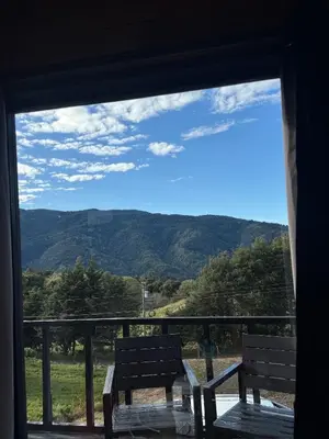 a window with two benches looking out at the mountains at Cabaña La Trinidad de Dota in El Copey