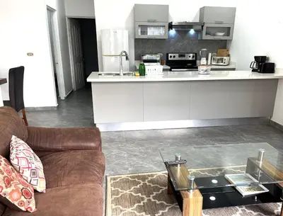 a living room with a couch and a table in a kitchen at Villas Portofino in Tamarindo