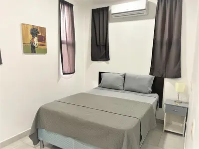 a small bedroom with a bed and a window at Villas Portofino in Tamarindo