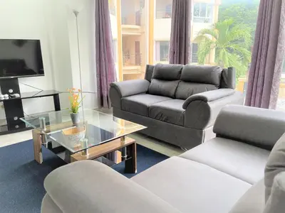 a living room with two couches and a tv at Villas Portofino in Tamarindo