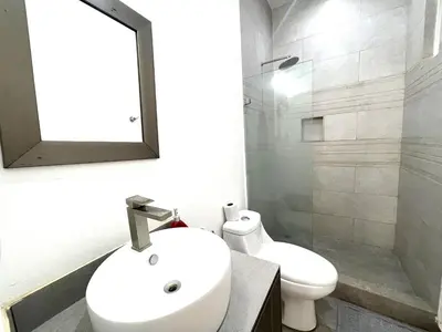 a bathroom with a sink and a toilet and a mirror at Villas Portofino in Tamarindo