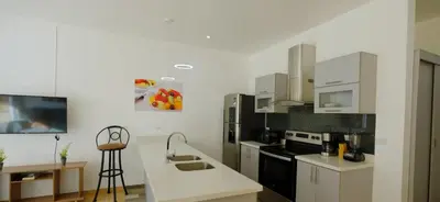 a kitchen with white cabinets and black appliances at Villas Portofino in Tamarindo