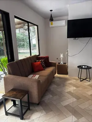 a living room with a couch and a flat screen tv at Villa Fortuna in San José Pinilla