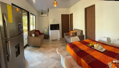 a kitchen and living room with a table and a living room at Villa Fortuna in San José Pinilla