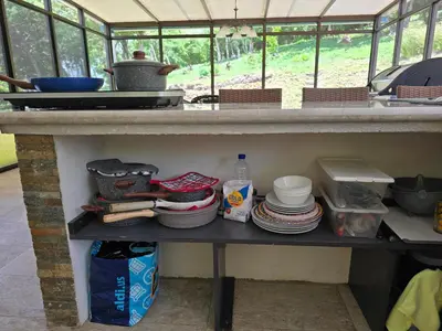 a kitchen counter with plates and dishes on a shelf at 2 Bedroom Guest House with Pool in Hacienda Miravalles