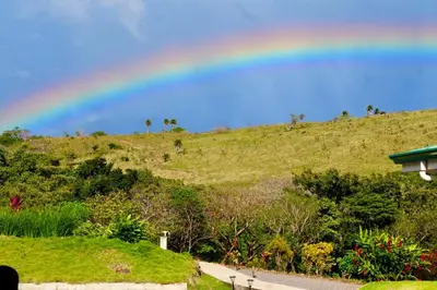 a rainbow in the sky over a hill at 2 Bedroom Guest House with Pool in Hacienda Miravalles