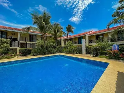 a swimming pool in front of a resort at Casa Rosa del Mar in Coco