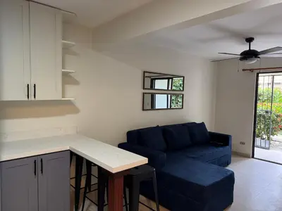a living room with a blue couch and a table at Casa Rosa del Mar in Coco