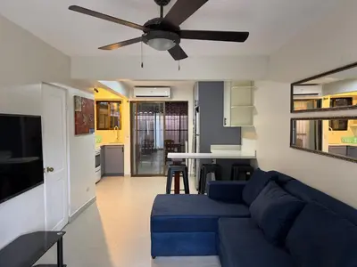 a living room with a blue couch and a ceiling fan at Casa Rosa del Mar in Coco