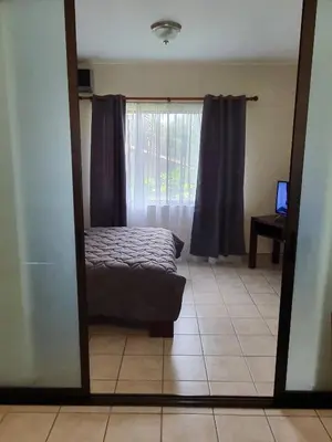 a mirror reflection of a bedroom with a bed and a window at Marina Loft Condos 212 in Coco