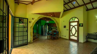 a room with a hallway with a kitchen and a door at Arenal Tropical Home Villa in Fortuna