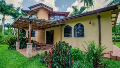a house with a patio in the yard at Arenal Tropical Home Villa in Fortuna