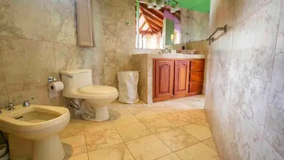 a bathroom with a toilet and a sink at Arenal Tropical Home Villa in Fortuna
