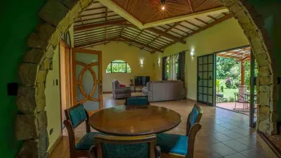 a living room with a wooden table and chairs at Arenal Tropical Home Villa in Fortuna