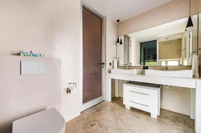 a white bathroom with two sinks and a mirror at Costa Rica Luxury Ocean View in Playa Ostional