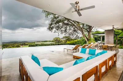 an outdoor patio with blue chairs and a pool at Costa Rica Luxury Ocean View in Playa Ostional