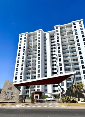 a large white building with a sculpture in front of it at Jacó Pacífico in Jacó