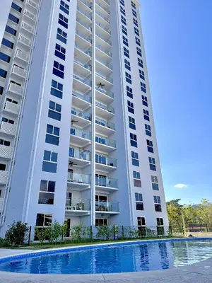 a large white apartment building with a swimming pool at Jacó Pacífico in Jacó