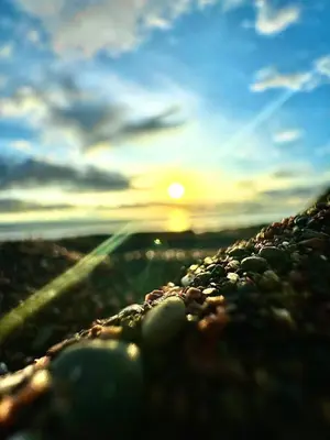 a view of the sunset from the ground with rocks at Jacó Pacífico in Jacó