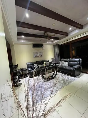 a living room with black leather couches and a rug at Condo Roldan macaw 12 Jaco Unique,with access to the sea in Jacó
