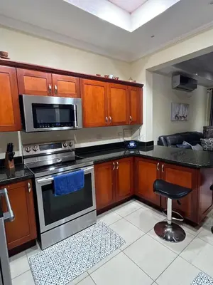 a kitchen with wooden cabinets and stainless steel appliances at Condo Roldan macaw 12 Jaco Unique,with access to the sea in Jacó