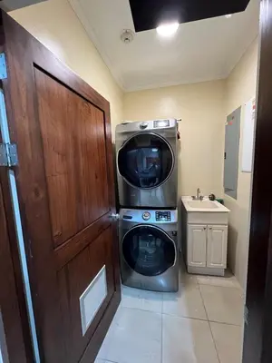 a washer and dryer in a bathroom with a door at Condo Roldan macaw 12 Jaco Unique,with access to the sea in Jacó