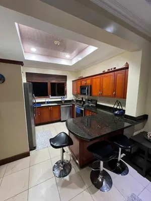 a kitchen with a large island with bar stools at Condo Roldan macaw 12 Jaco Unique,with access to the sea in Jacó