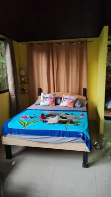 a bed with a blue comforter and pillows on it at Villa Los Colibrí 11 in Agua Blanca
