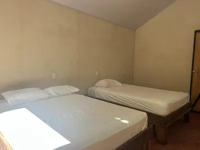 two beds in a small room with at Cabañas Playa Cedros in Puntarenas