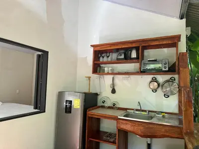 a small kitchen with a sink and a refrigerator at Cabañas Playa Cedros in Puntarenas