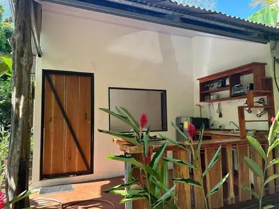 a house with a door and a plant in front of it at Cabañas Playa Cedros in Puntarenas