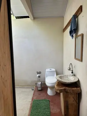 a bathroom with a toilet and a sink at Cabañas Playa Cedros in Puntarenas