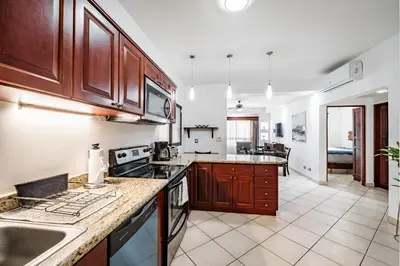 a kitchen with wooden cabinets and a counter top at Beautiful Condo, Tamarindo Costa Rica in Huacas