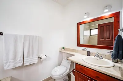 a bathroom with a sink and a toilet and a mirror at Beautiful Condo, Tamarindo Costa Rica in Huacas