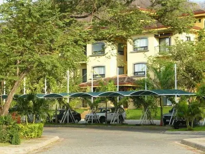 a group of tables with umbrellas in front of a building at Beautiful Condo, Tamarindo Costa Rica in Huacas