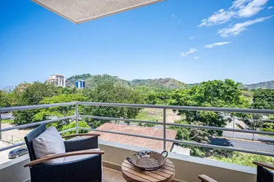 a balcony with chairs and a table and a view at Beautiful Jaco Apartment CL 1-23 - Just a short walking distance to the beach in Jacó