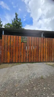 a wooden gate in front of a house at Casita el Jardin in Nuevo Arenal
