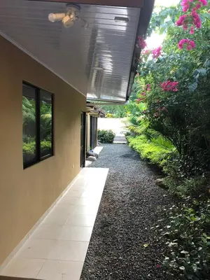 a hallway of a building with flowers and plants at Casa Monos in Quepos