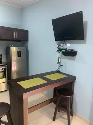 a desk in a kitchen with a television on a wall at Casa Monos in Quepos