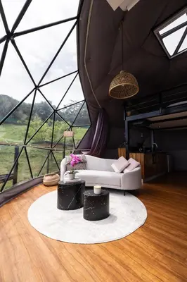 a living room with a couch in a tent at Domo Mágico en las Alturas, EL SOL in San José