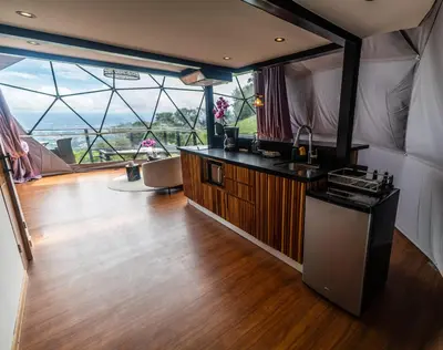 a large room with a kitchen and a large window at Domo Mágico en las Alturas, EL SOL in San José