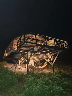 a building with a roof on a field at night at Domo Mágico en las Alturas, EL SOL in San José