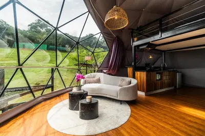 a living room with a couch and a large window at Domo Mágico en las Alturas, EL SOL in San José