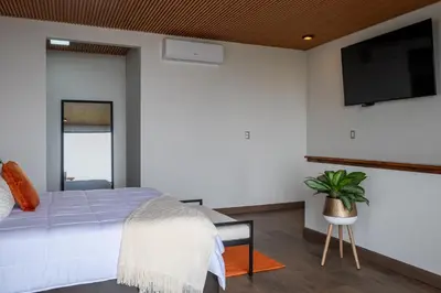 a bedroom with a bed and a flat screen tv at ÉWA Homes Monteverde in Monteverde Costa Rica